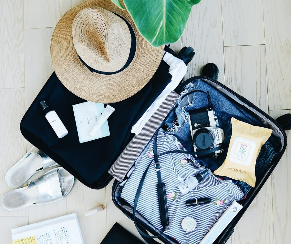 Travel packing list items in suitcase